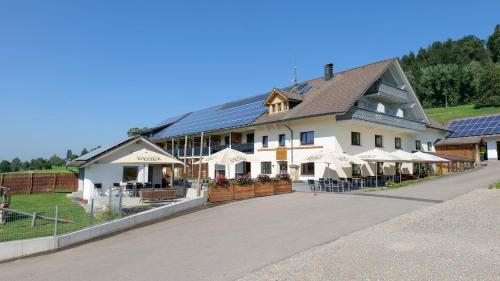 a large building with white umbrellas in front of it at Müller's Stuben in Isny im Allgäu