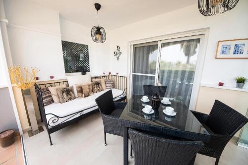 Una sala de estar con una mesa y una cama. en Townhouse overlooking golf course, en Las Armeras