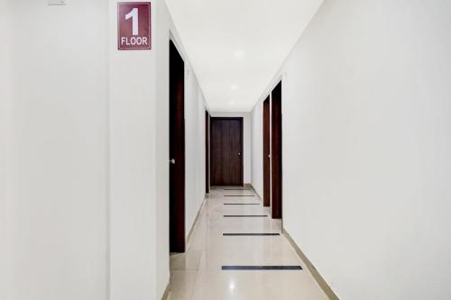 a hallway with white walls and a sign that reads floors at Hotel O Arusai Inn in Pune