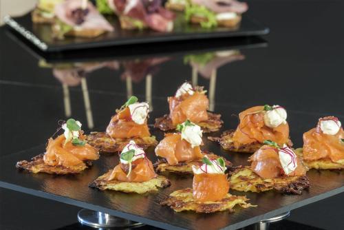 a bunch of appetizers on a plate on a table at NH Collection Köln Mediapark in Cologne