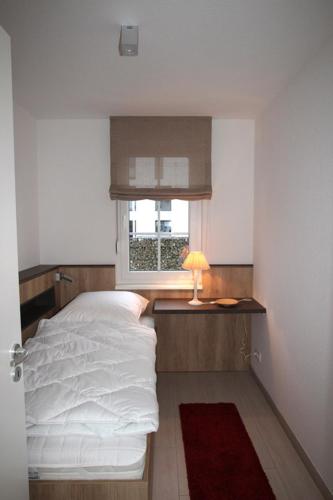 a small bedroom with a bed and a window at Dorothee 1 in Nienhagen