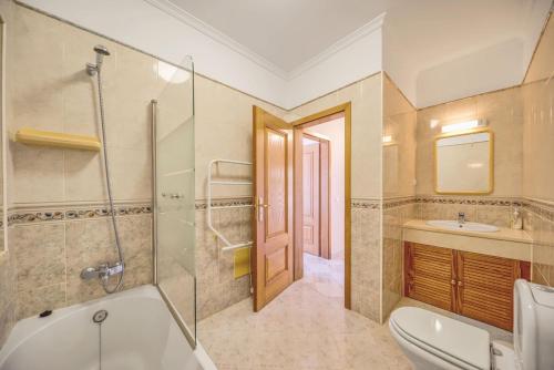a bathroom with a tub and a toilet and a sink at Casa Vista Cumeada in Canhestros