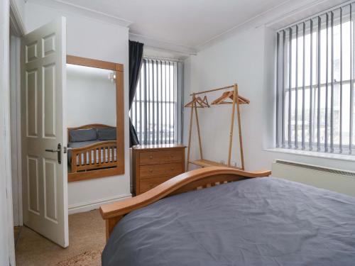 a bedroom with a bed and a dresser and windows at Duncan Square in Whitehaven