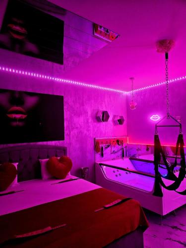 Una habitación rosa con dos camas y una bañera. en Secret love room, en Bucarest