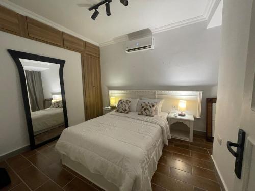 a bedroom with a white bed and a mirror at Modern Boho Chalet in Central Sharm El Sheikh in Sharm El Sheikh