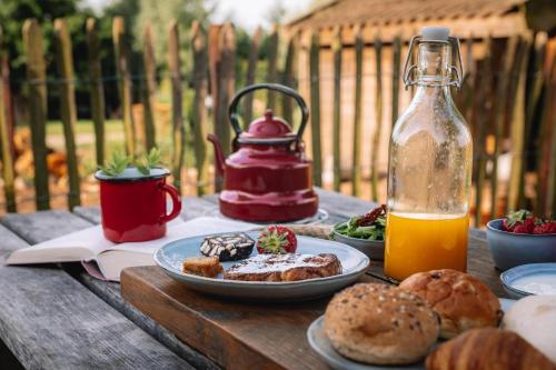 a table with a plate of food and a bottle of juice at Landhoeve in Zwarteweg