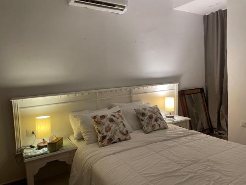 a bedroom with a white bed with two pillows at Modern Boho Chalet in Central Sharm El Sheikh in Sharm El Sheikh