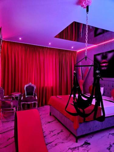 Habitación roja con cama con columpio en Secret love room, en Bucarest