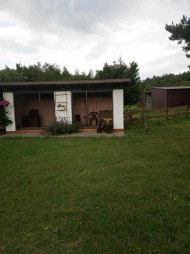 a small house with a grass field in front of it at Agroturystyka Renatka 