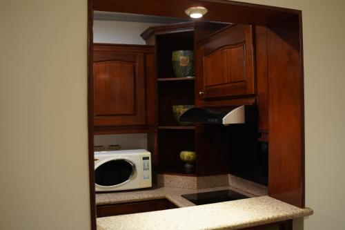 アル・コバールにあるوردة الرمال للأجنحة الفندقيةのキッチン(木製キャビネット、電子レンジ付)