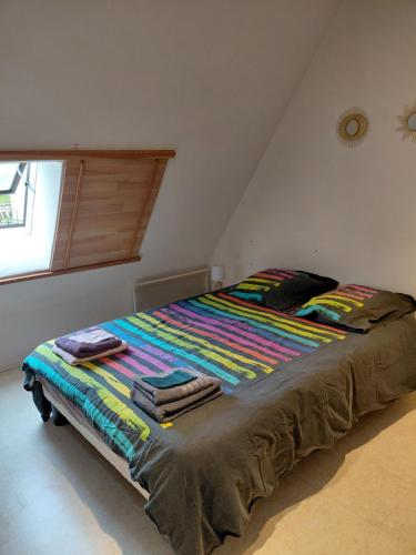 un grand lit avec une couverture colorée dessus dans une chambre dans l'établissement Saint Georges, à Villaines-sous-Lucé