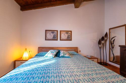 a bedroom with a bed with a blue comforter at Rifugio Del Sognatore Stintino in Cuile Pazzoni