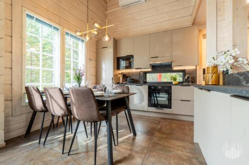 a kitchen with a dining room table and chairs at Levi Kätkänlinna 20A by Holiday in Lapland in Kittilä