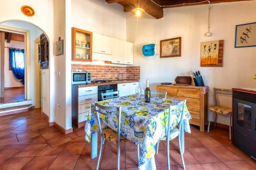 a kitchen with a table with a table cloth on it at Rifugio Del Sognatore Stintino in Cuile Pazzoni