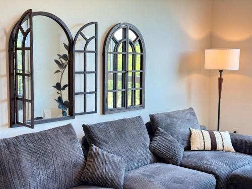 a living room with a couch and two mirrors at Sunlit Retreat 10 Min from Disneyland With Pool & GYM in Tustin