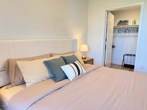 a bedroom with a large white bed with pillows at Sunlit Retreat 10 Min from Disneyland With Pool & GYM in Tustin