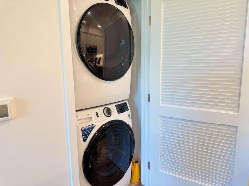 a washing machine and a dryer in a room at Sunlit Retreat 10 Min from Disneyland With Pool & GYM in Tustin