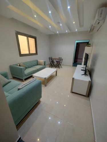 a living room with two couches and a table at شقق الهجرة 101 in Al Madinah