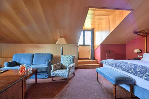a bedroom with a bed and a couch and a chair at Hotel Fontecruz Ávila in Avila