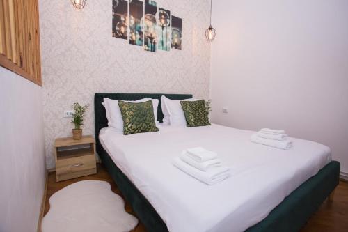 Un dormitorio con una cama con sábanas y almohadas blancas. en Joseph Hayn Apartments, en Sighişoara