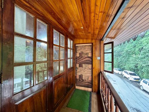 an empty room with a balcony with windows at ukiyo homes in Darjeeling