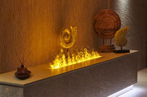 a water feature in a room with a fireburning at Wellness & Spa Hotel Kaskady in Sliač
