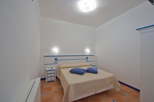 een slaapkamer met een bed met twee blauwe kussens erop bij Le Anfore 2 - Amalfi Coast in Conca dei Marini