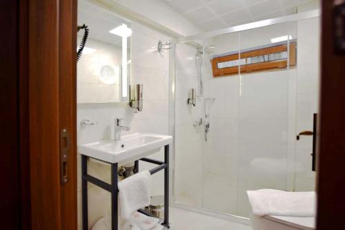 a white bathroom with a sink and a shower at Hotel Öncü in Istanbul