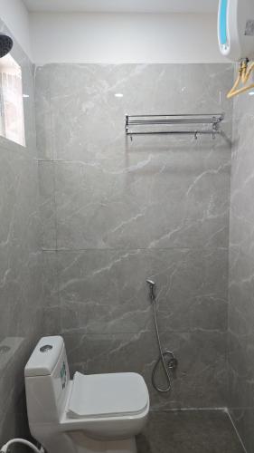 a bathroom with a white toilet and a wall at Hotel EVA in Gundipet