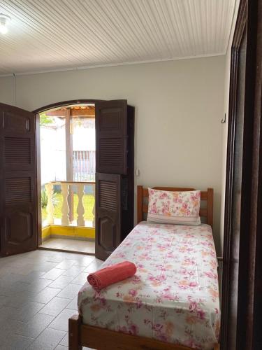 a bedroom with a bed and a door to a balcony at Casa Mosqueiro, Praia do Farol e Chapéu Virado in Mosqueiro