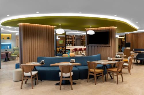 a restaurant with tables and chairs and a green ceiling at Hampton By Hilton Istanbul Sisli in Istanbul