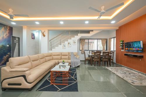 a living room with a couch and a table at ll EMPYREAN STAY ll CELESTIAL UNICORN VILLA ll 3BHK ll AC ll PVT POOL ll FREE WIFI ll in Lonavala