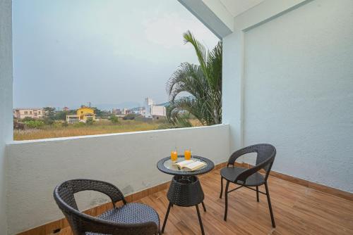a small table and chairs on a balcony with a view at ll EMPYREAN STAY ll CELESTIAL UNICORN VILLA ll 3BHK ll AC ll PVT POOL ll FREE WIFI ll in Lonavala