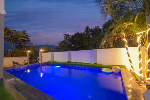 a swimming pool with blue lighting in a backyard at night at ll EMPYREAN STAY ll CELESTIAL UNICORN VILLA ll 3BHK ll AC ll PVT POOL ll FREE WIFI ll in Lonavala