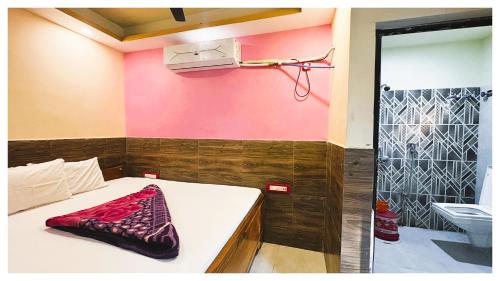 a room with a bed and a bathroom with pink walls at স্বস্তিকা Swash-Tikaa Digha Near Sea Beach AC Or Non AC Room in Digha
