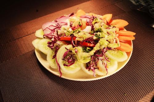 a plate of food with a salad on a table at Hotel Balaji Inn, Ayodhya Bypass in Bhopal