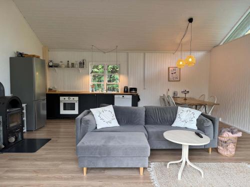 a living room with a gray couch and a kitchen at Vacation home 1 minute away from the Beach in Yderby