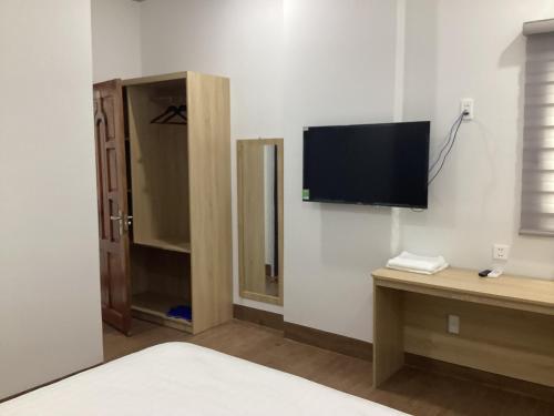 a bedroom with a tv on the wall and a mirror at Hotel88 in Ấp Bình Hưng