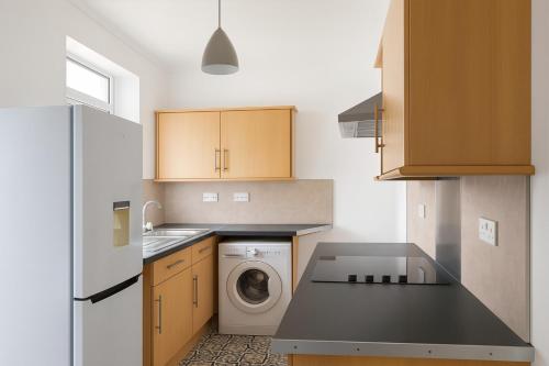 a kitchen with a washing machine and a washer at Coastal Haven - Steps From Beach in Whitehaven