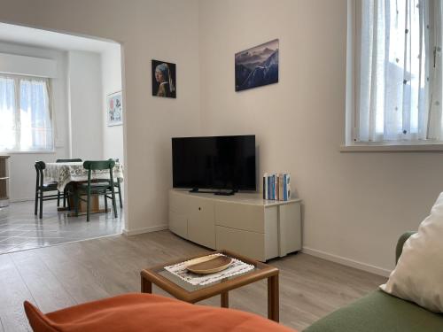 ein Wohnzimmer mit Fernseher, Couch und Tisch in der Unterkunft Casa Rio Maggiore in Levico Terme