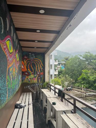 a mural on the side of a building with benches at Hotel Krishna in Rishīkesh