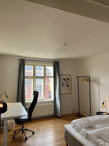 a bedroom with a desk and a bed and a window at Stunning 6-Pax Valby in Copenhagen