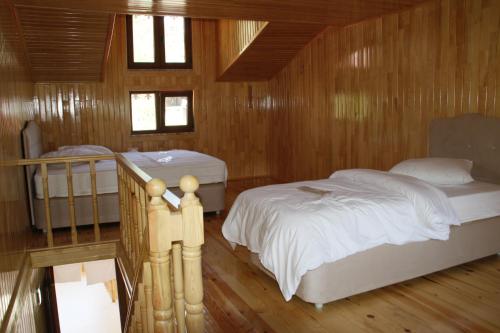 een slaapkamer met 2 bedden in een houten hut bij Ataköy Otel Cafe Restaurant in Çaykara