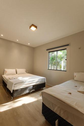 two beds in a room with a window at Vila Topo do Mundo in Guaraciaba do Norte