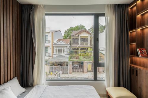 ein Schlafzimmer mit einem Bett und einem großen Fenster in der Unterkunft Alley Villa in Xuan An