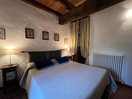 a bedroom with a large white bed with blue pillows at The Tower in Borgo Fontanini in Monte Ombraro