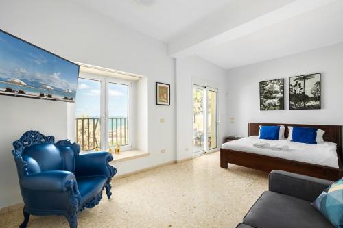 a bedroom with a bed and a blue chair at Hatsuk 18 in Bet Yannay