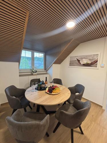 a dining room with a wooden table and chairs at Apartman O Terme Olimia in Ravne na Koroškem