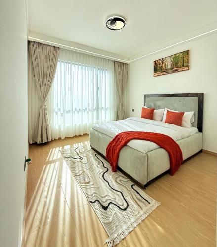 a bedroom with a large bed and a rug at Royal essence apartment with swimming pool ,ample parking ,fully equipped gym, child playground and amazing scenic city view in lavington in Nairobi