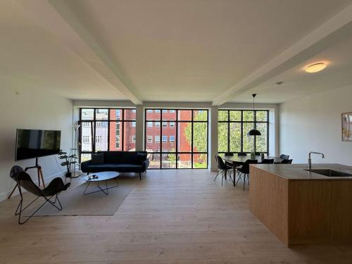 a large living room with a couch and a table at Cozy Odense Apartment Long Term Stay in Odense